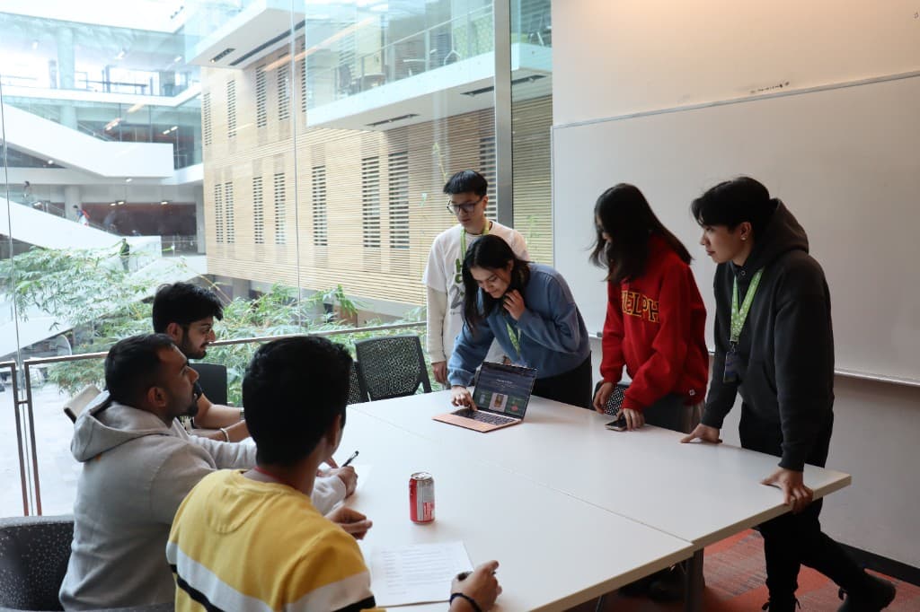 A team huddled around a laptop during a hackathon